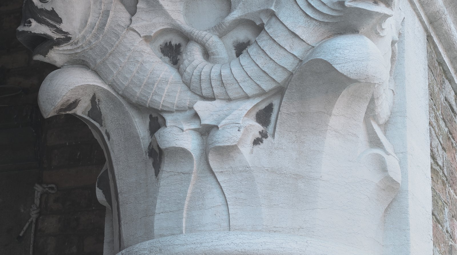Stone carving detail and fish stalls inside the Rialto fish market hall.