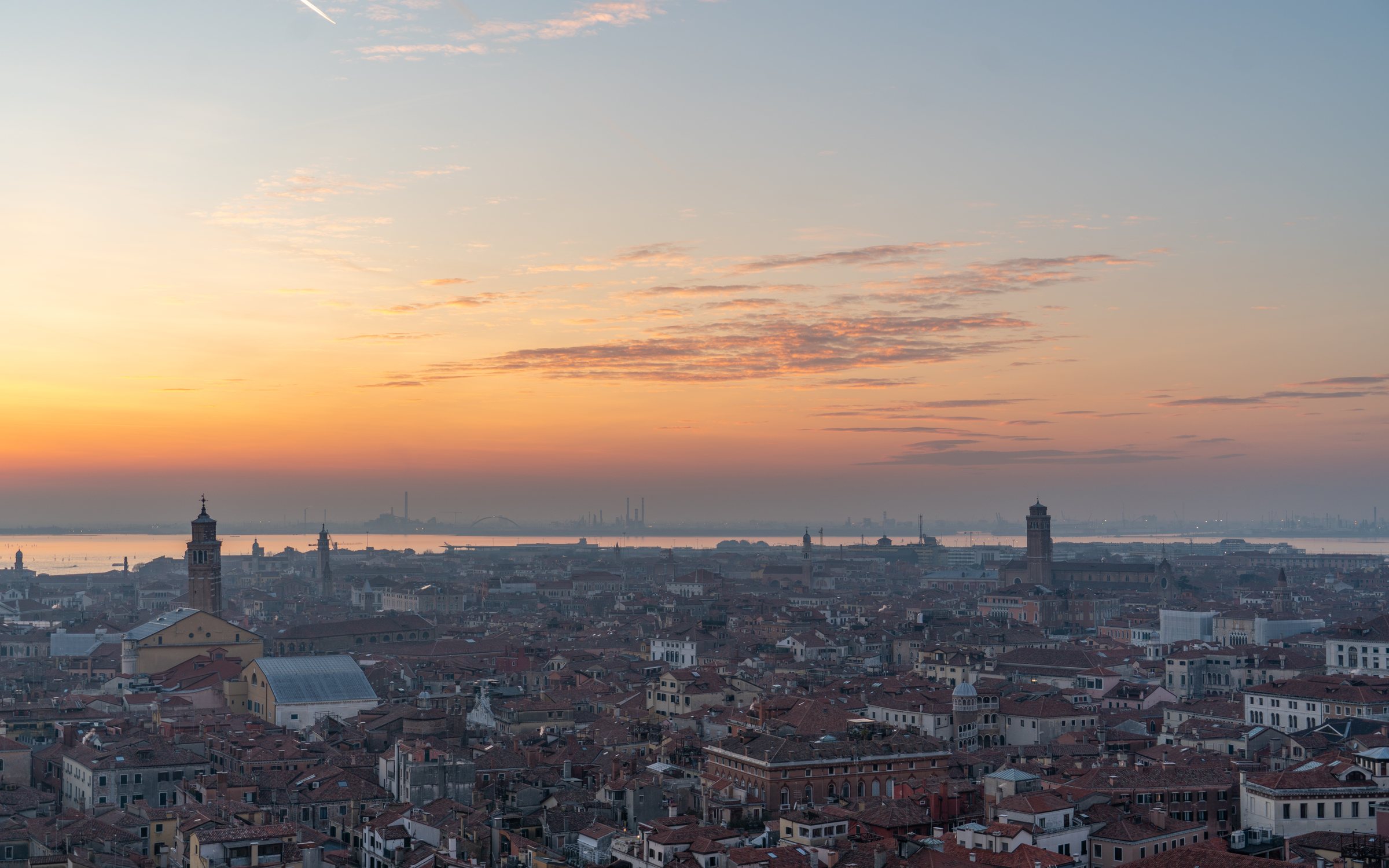 Rooftops of Venice at sunset, looking out across the lagoon toward the mainland.