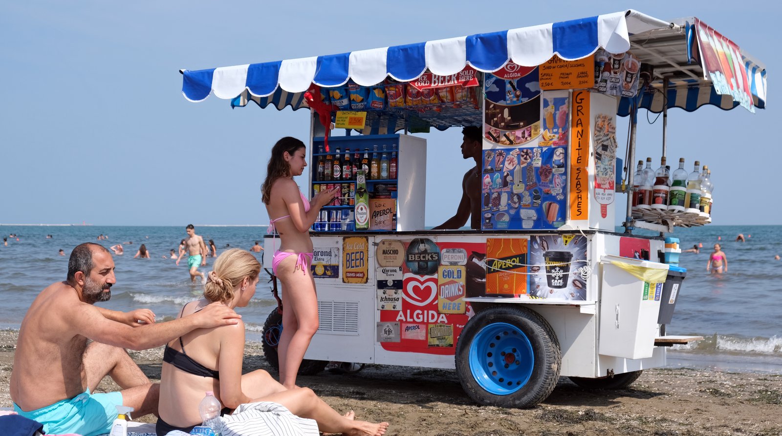 A beach vendor walking the sand at Lido di Venezia.