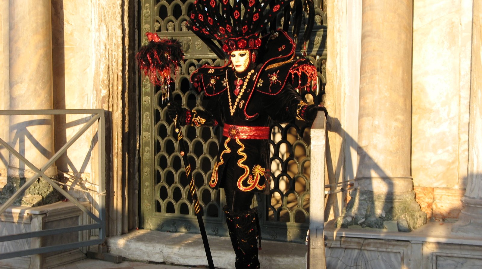 A person wearing a traditional Venetian Carnevale mask and costume.